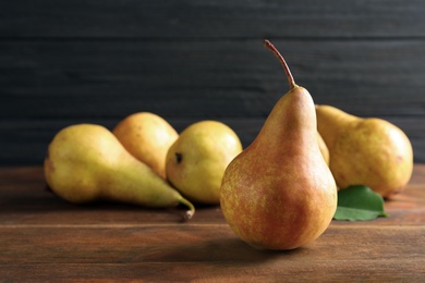 Photo of Ripe pear on wooden table. Space for text