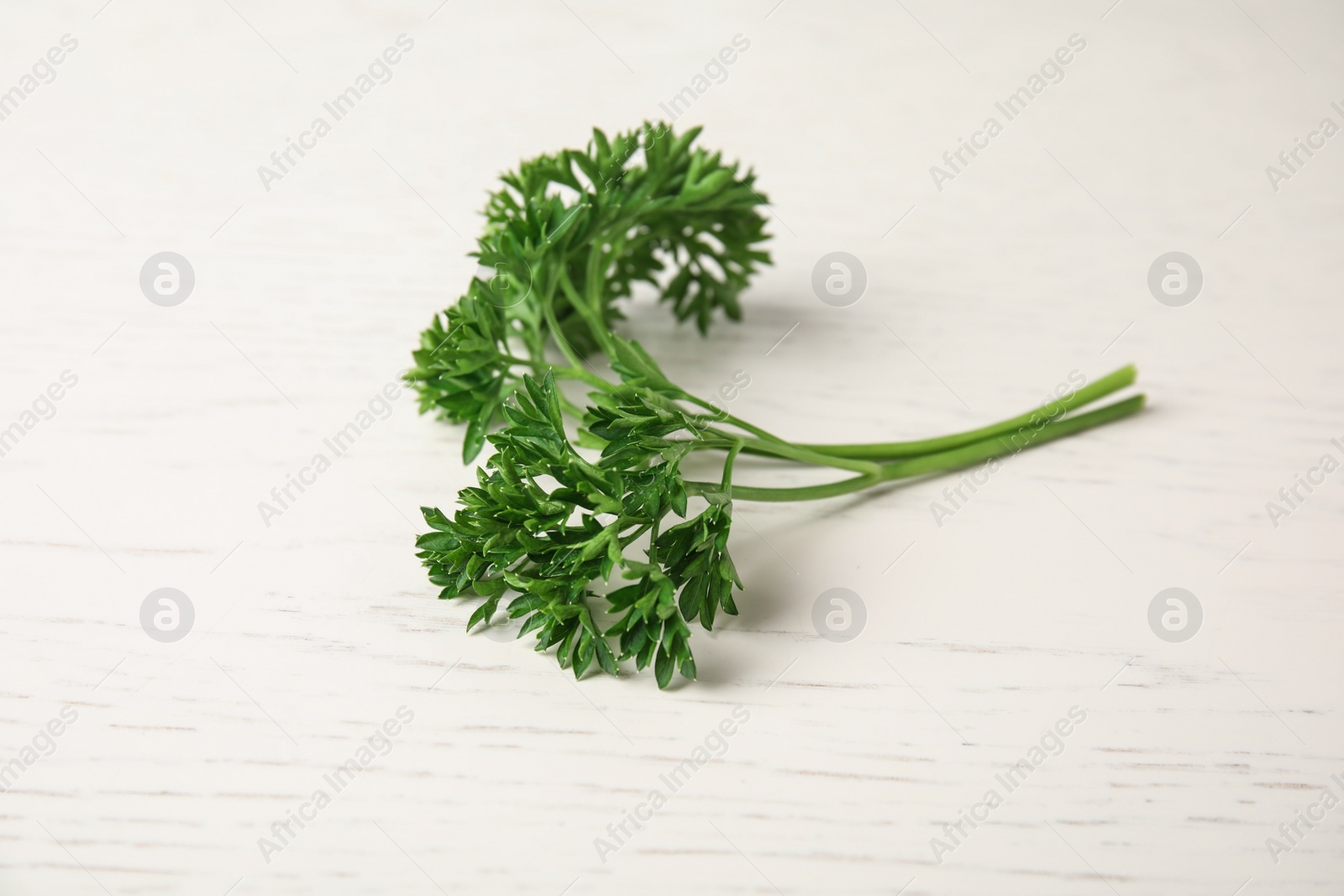 Photo of Fresh green parsley on white wooden table