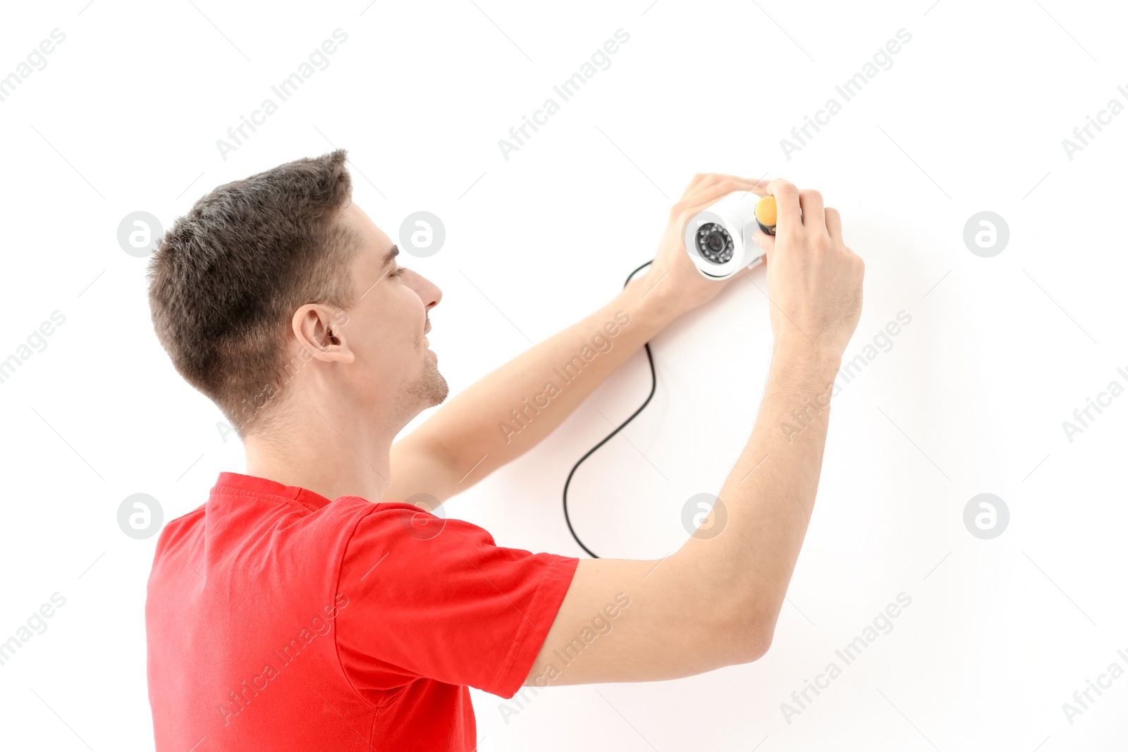 Photo of Technician installing CCTV camera on wall indoors