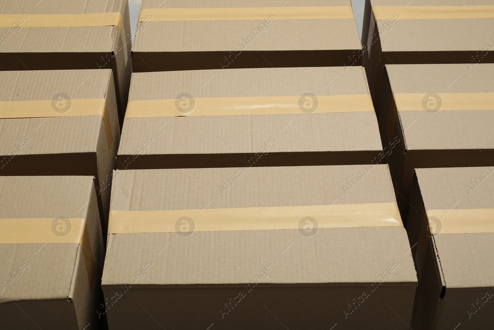 Photo of Many closed cardboard boxes with tape as background