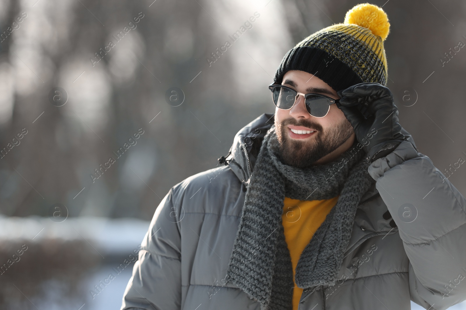 Photo of Portrait of handsome young man with sunglasses on winter day outdoors