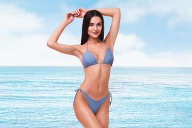 Smiling woman in stylish bikini near sea
