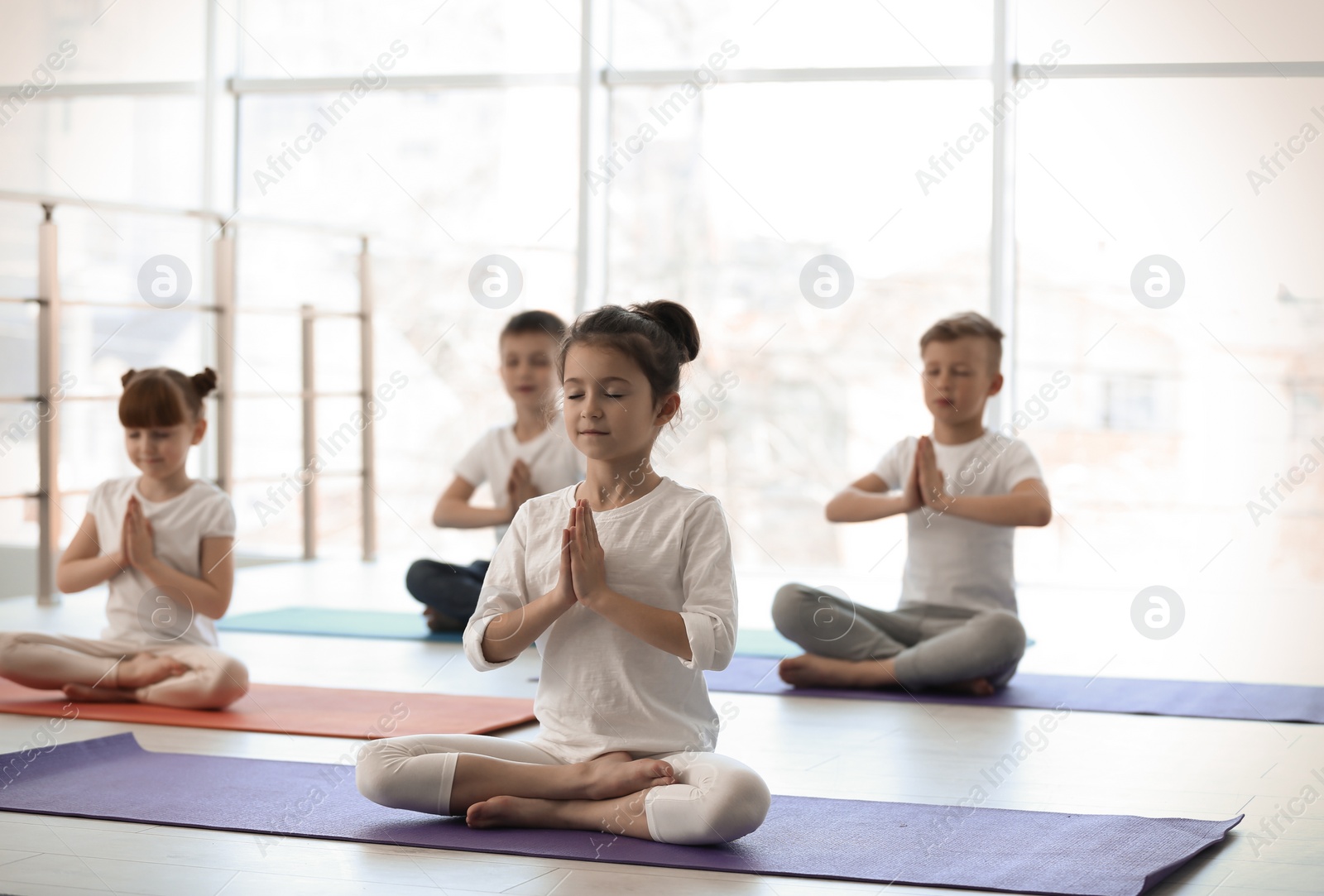 Photo of Little children practicing yoga in gym