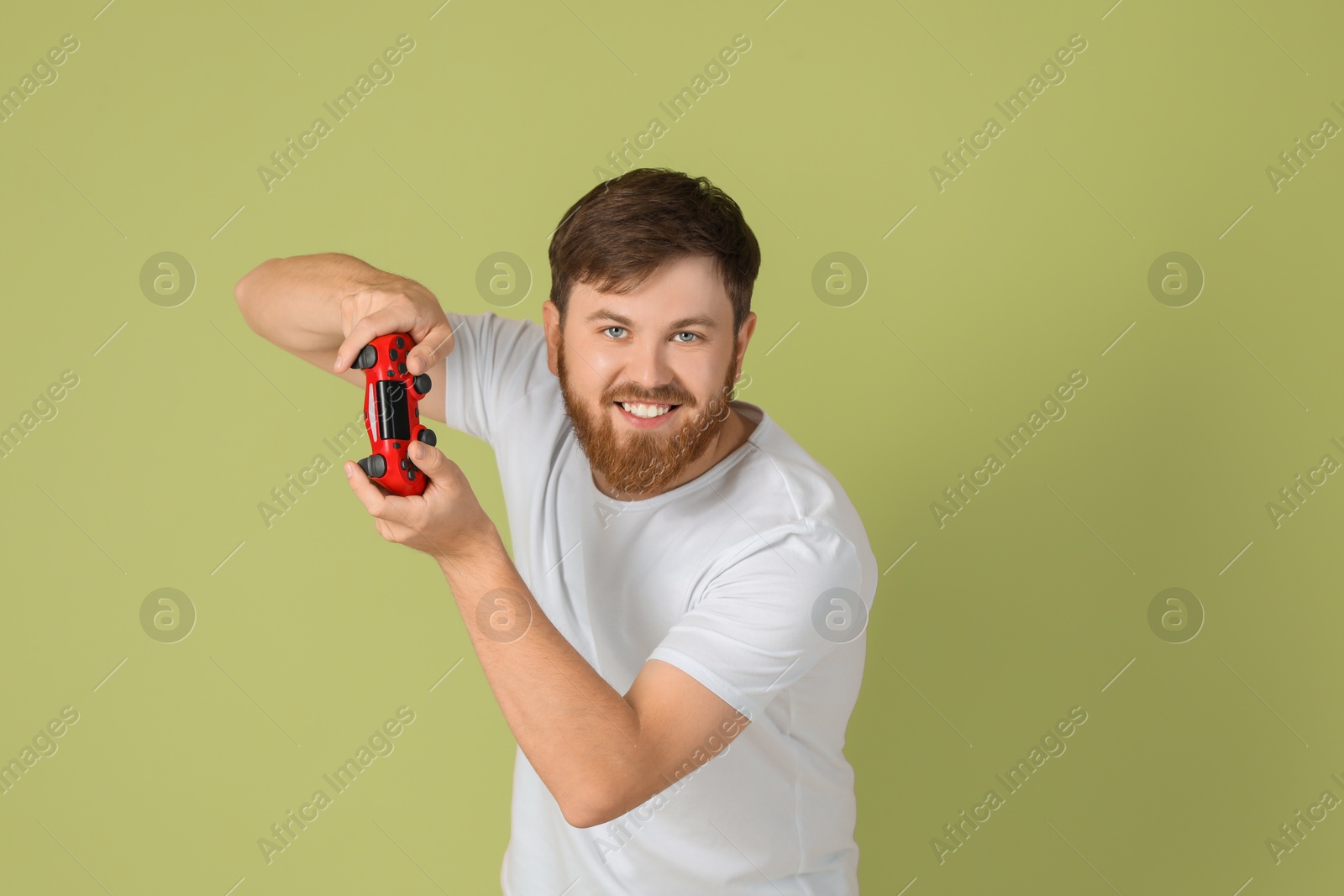 Photo of Happy man playing video game with controller on pale green background