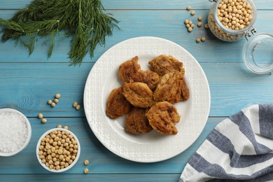 Flat lay composition with cooked soy meat on light blue wooden table