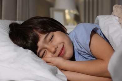 Photo of Cute little boy sleeping in bed at home