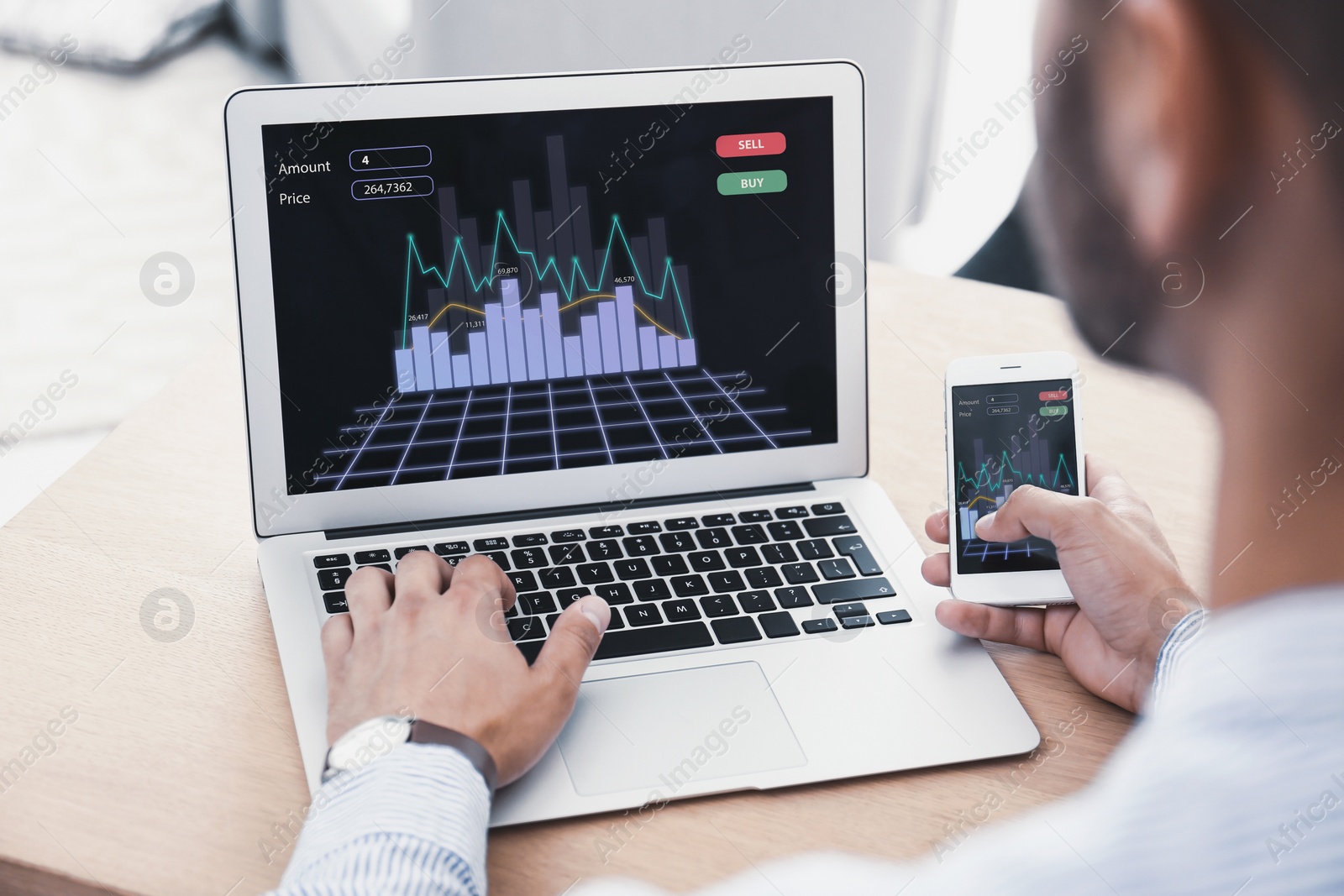 Image of Broker working with laptop and mobile phone at table, closeup. Forex trading