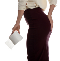 Woman with toilet paper suffering from hemorrhoid on white background, closeup