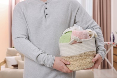 Man with basket full of laundry at home, closeup