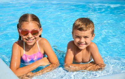 Happy children in swimming pool on sunny day