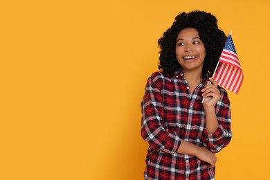 4th of July - Independence Day of USA. Happy woman with American flag on yellow background, space for text