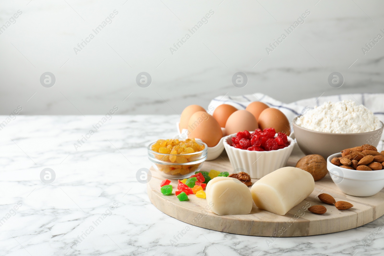 Photo of Marzipan and other ingredients for homemade Stollen on white marble table. Baking traditional German Christmas bread