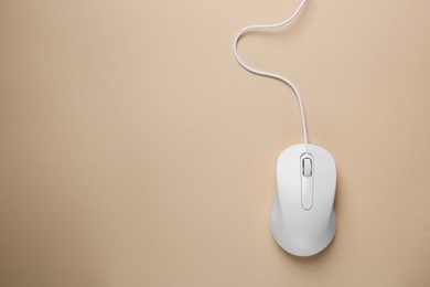 Photo of One wired mouse on beige background, top view. Space for text