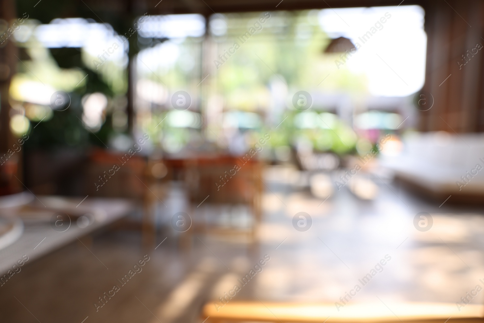 Photo of Blurred view of comfortable cafeteria with furniture