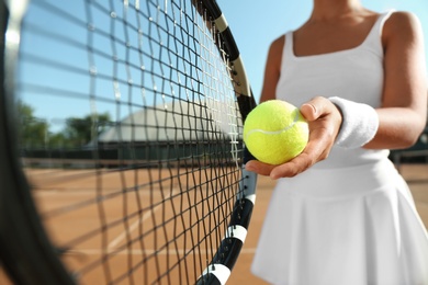 Photo of Sportswoman preparing to serve tennis ball at court, closeup