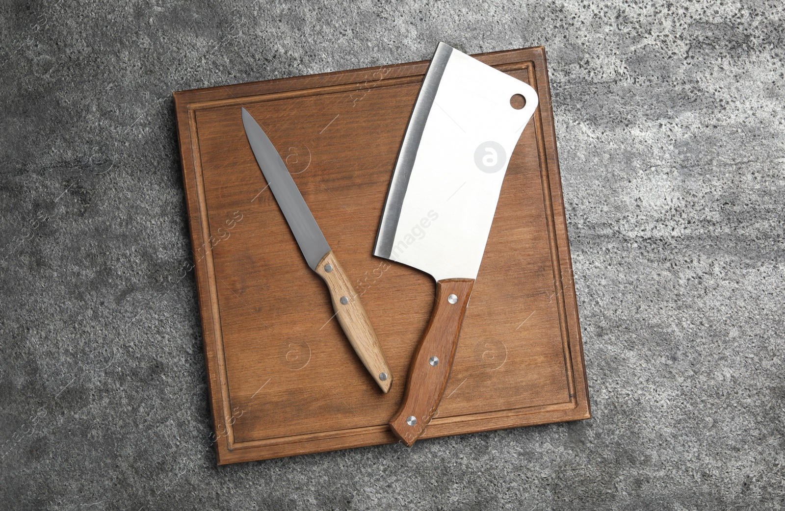 Photo of Knives on grey table, top view. Cooking utensils