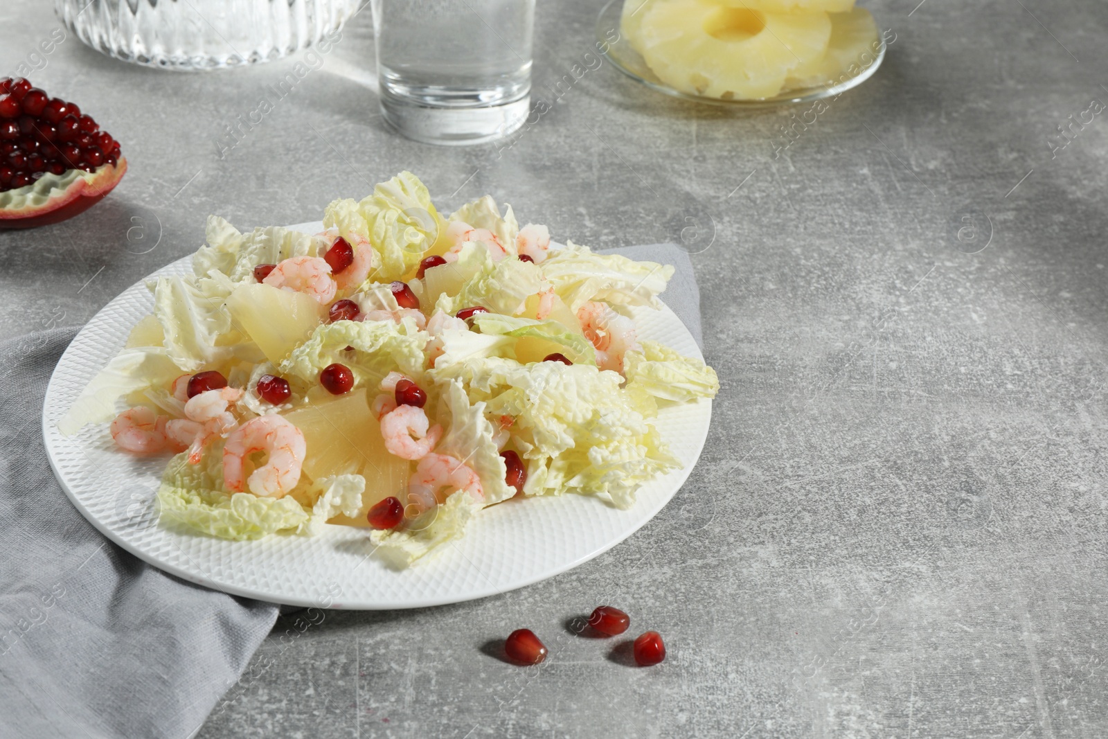 Photo of Delicious salad with Chinese cabbage, shrimps and pineapple served on grey table, space for text