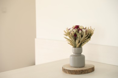 Photo of Beautiful bouquet of dry flowers on white table indoors, space for text