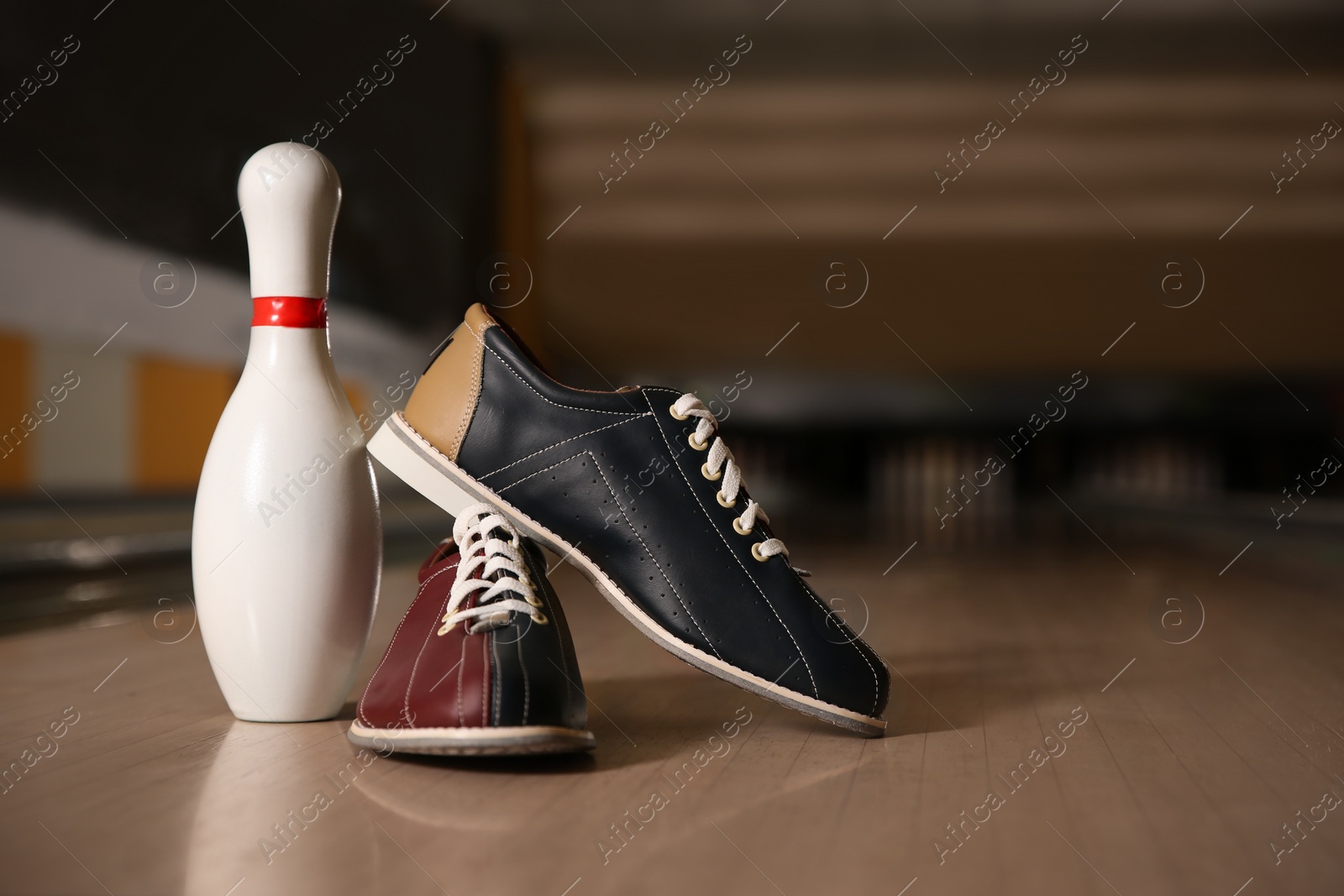 Photo of Shoes and pin on bowling lane in club. Space for text