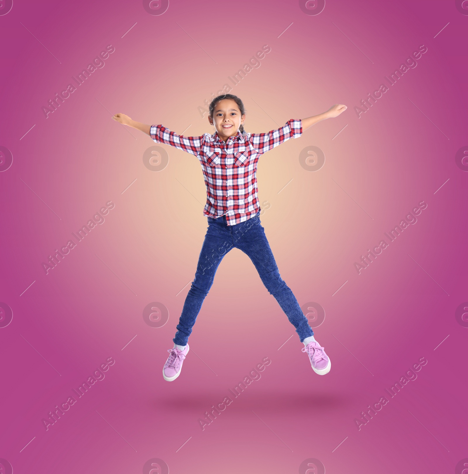 Image of Happy cute girl jumping on color gradient background