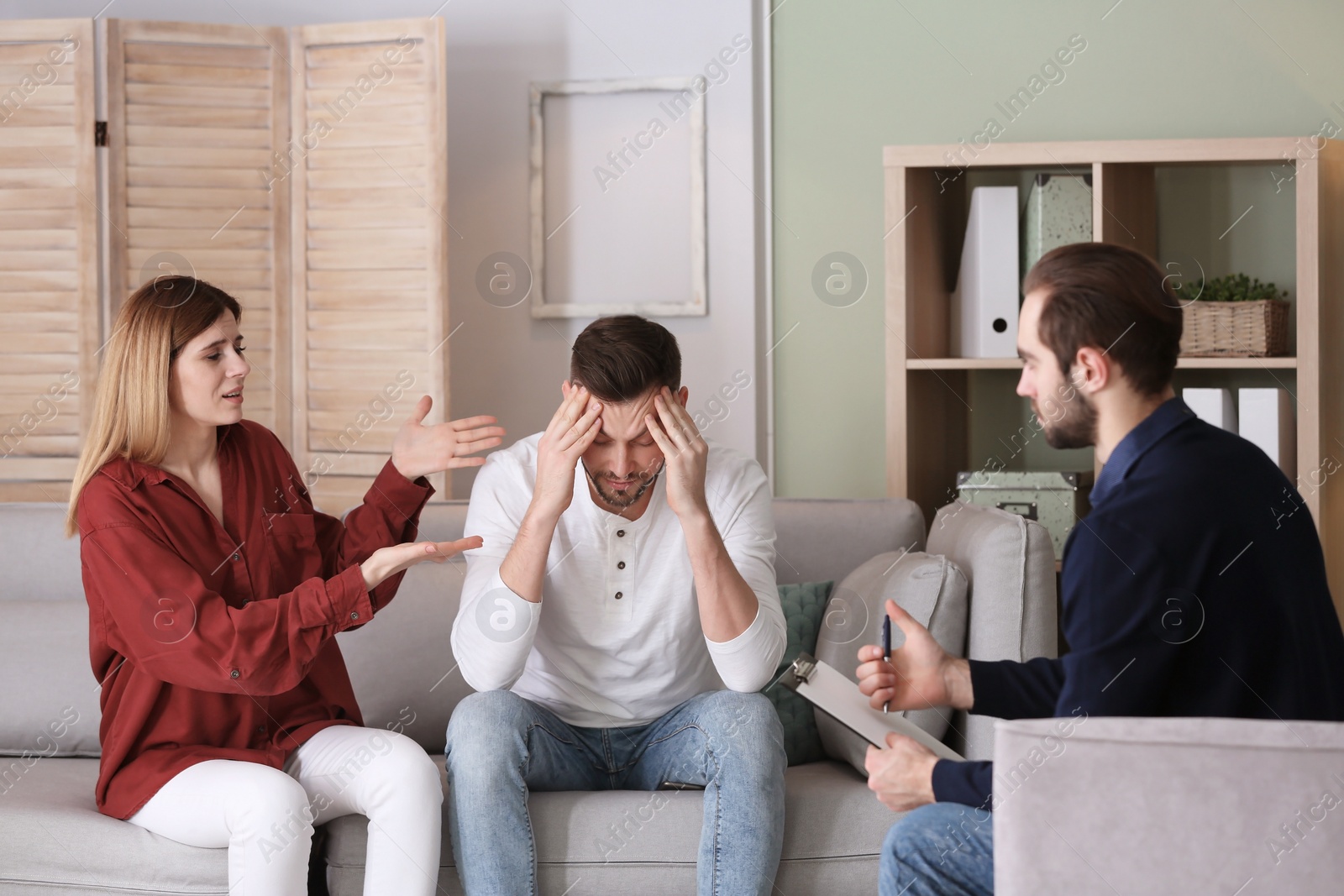 Photo of Family psychologist working with young couple in office