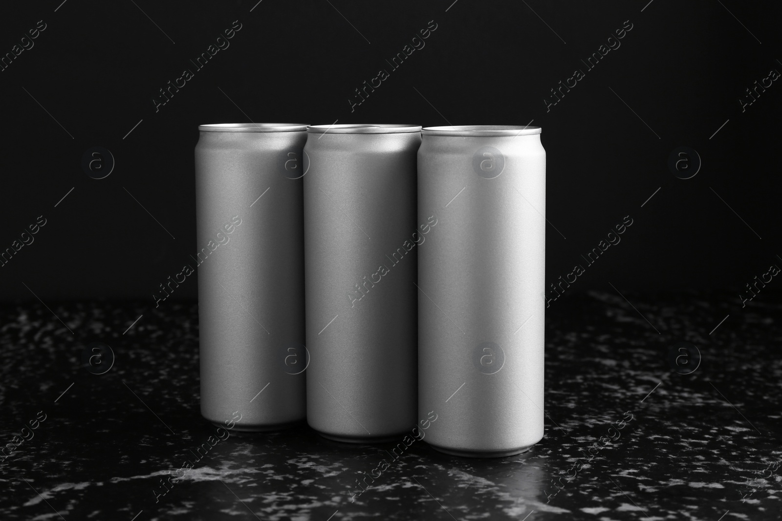 Photo of Energy drinks in cans on black textured table