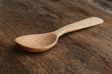 Photo of New clean empty spoon on wooden background