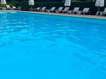 Photo of Outdoor swimming pool in luxury hotel on sunny summer day. Time for relax