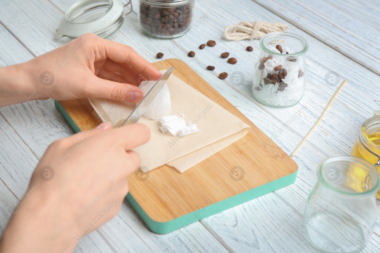 Photo of Woman making coffee candle at wooden table, closeup