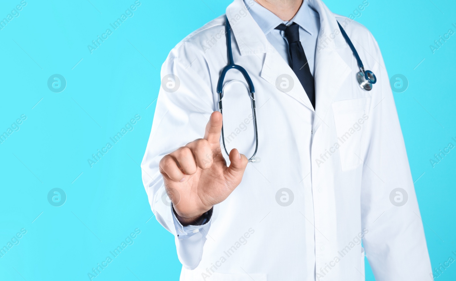 Photo of Male doctor pointing on color background, closeup