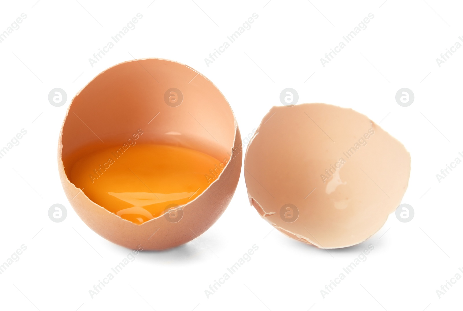 Photo of Cracked raw chicken egg with yolk on white background