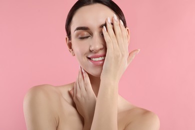 Portrait of beautiful young woman on pink background