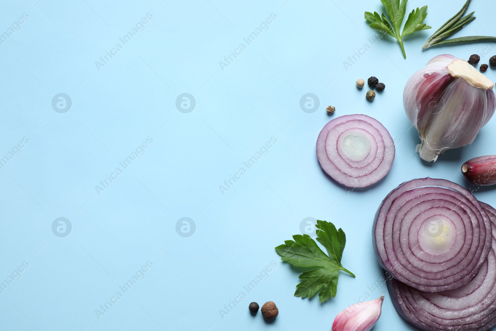 Photo of Flat lay composition with onion and spices on light blue background. Space for text