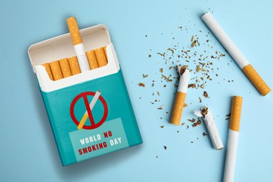 Image of World No Smoking Day. Pack and cigarettes on light blue background, flat lay