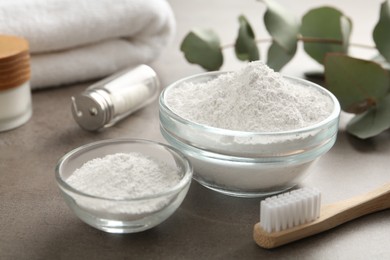 Tooth powder and brush on grey table, closeup