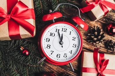 Flat lay composition with Christmas gifts and alarm clock on wooden table. Boxing day