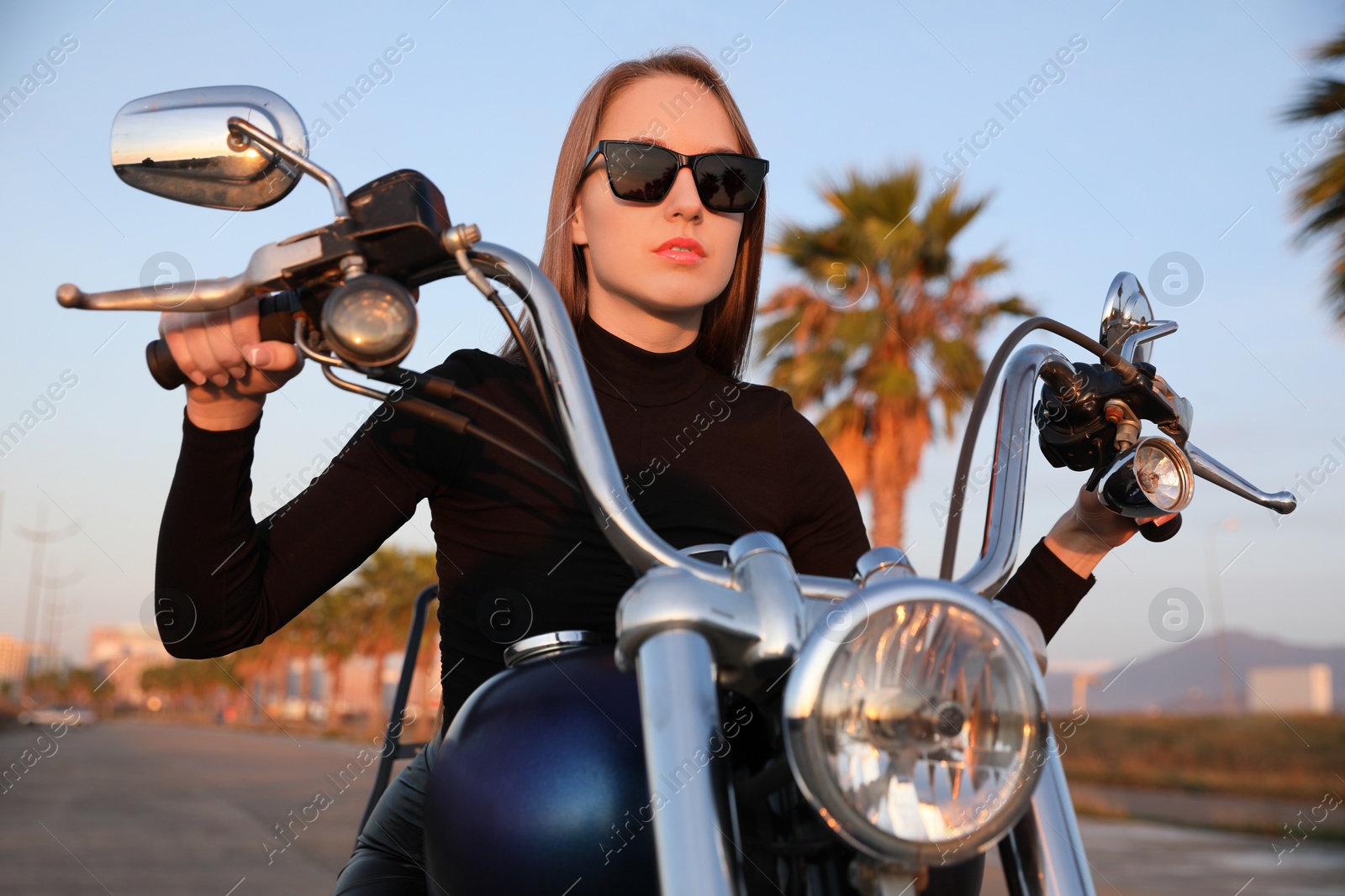 Photo of Beautiful young woman riding motorcycle on sunny day