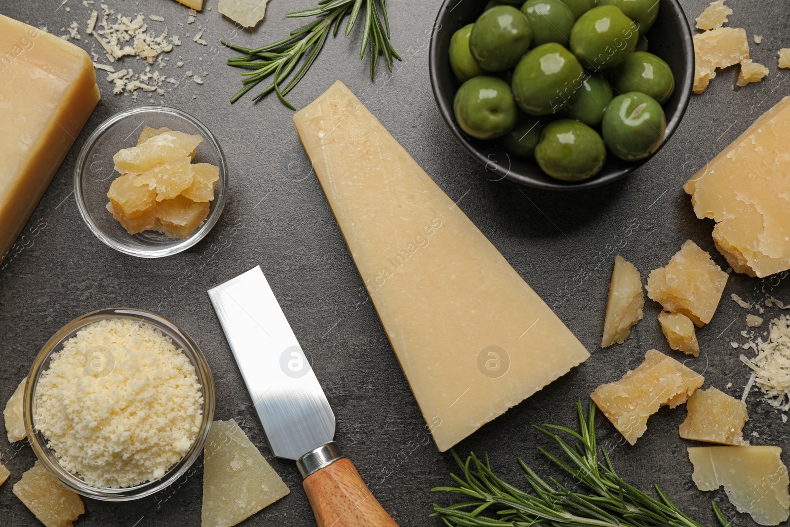 Photo of Flat lay composition with delicious Parmesan cheese on dark grey table