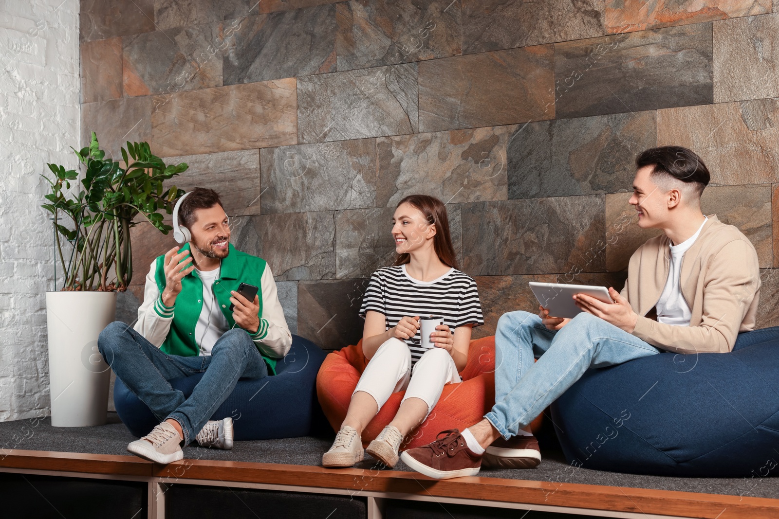 Photo of Office employees enjoying break together in recreation room at work