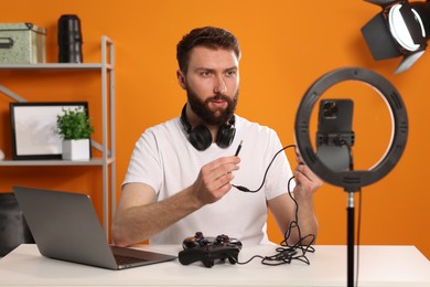 Technology blogger recording video review about game controllers at home