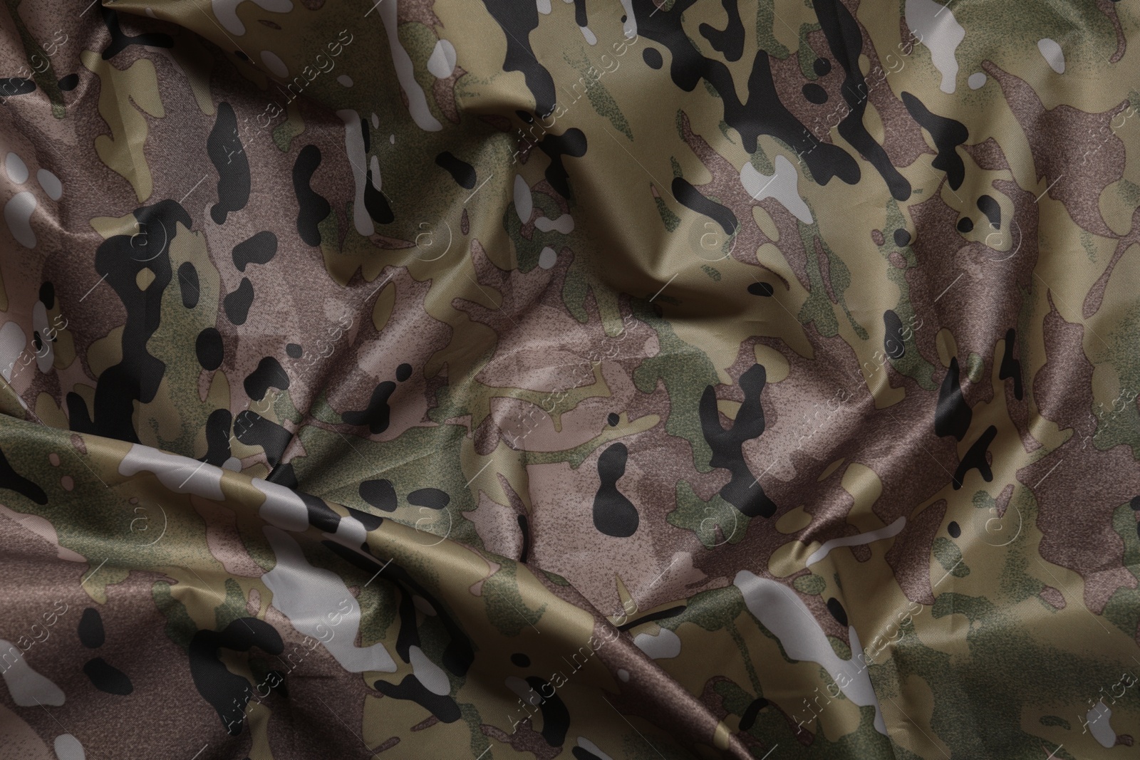 Photo of Texture of crumpled camouflage fabric as background, top view