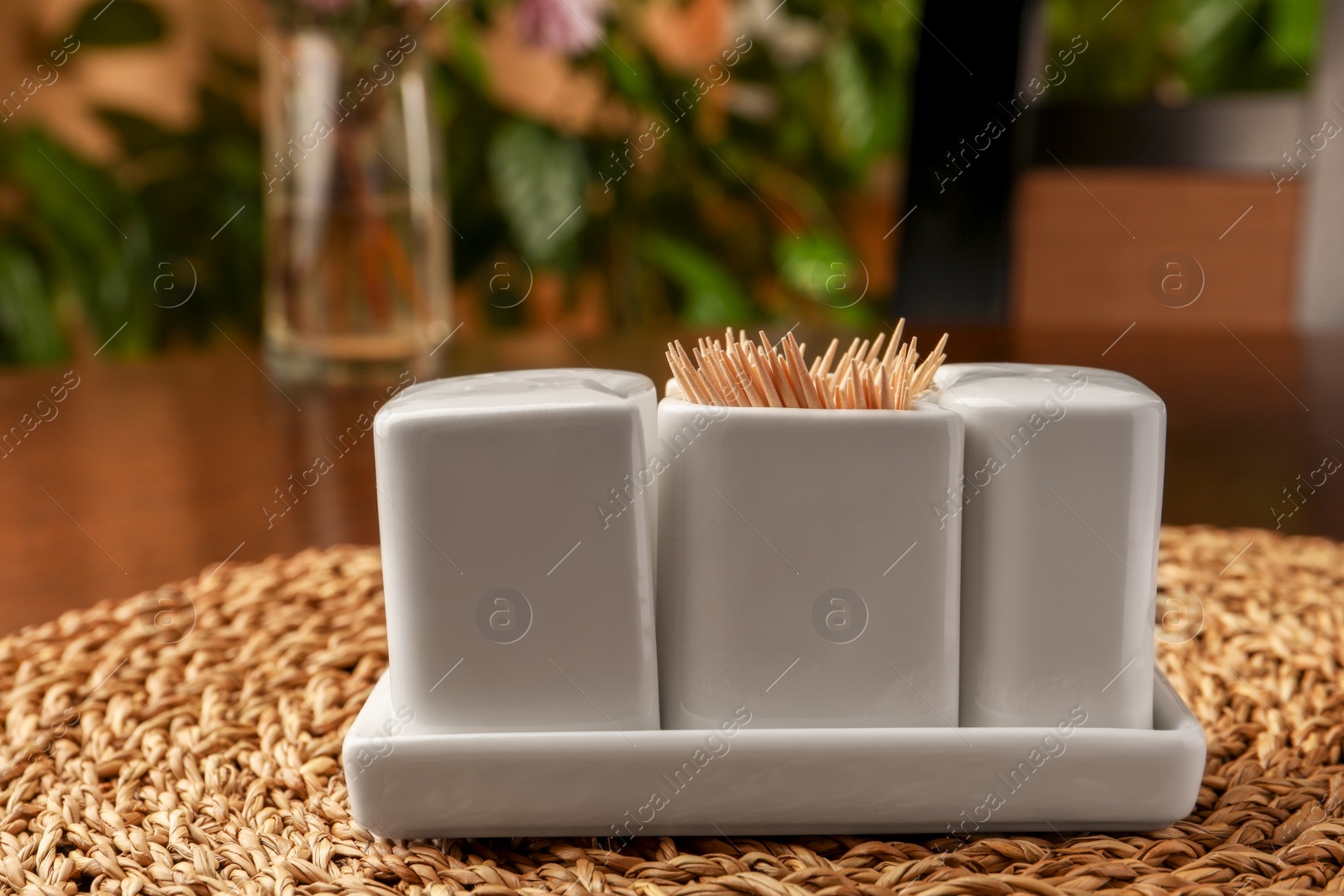 Photo of Holder with salt, pepper and toothpicks on wicker mat