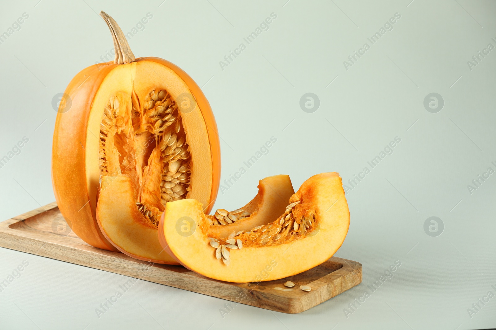 Photo of Cut fresh ripe pumpkin on white background, space for text