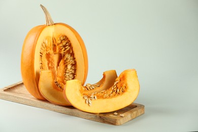 Photo of Cut fresh ripe pumpkin on white background, space for text