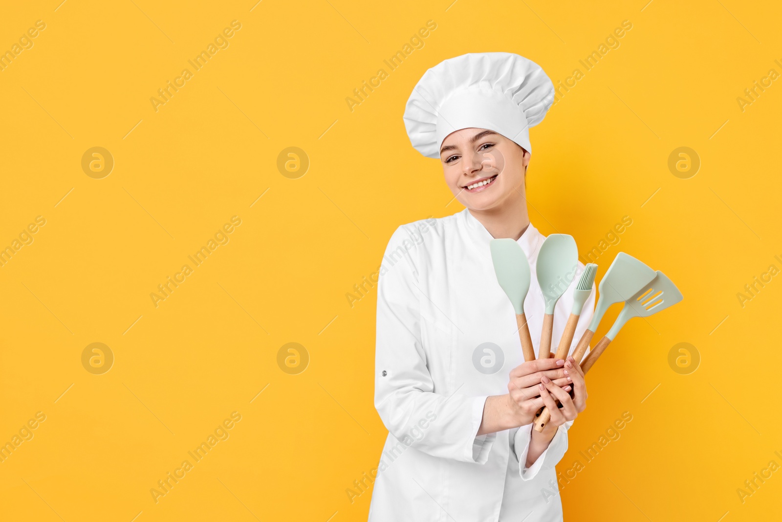 Photo of Professional chef with kitchen utensils on yellow background. Space for text