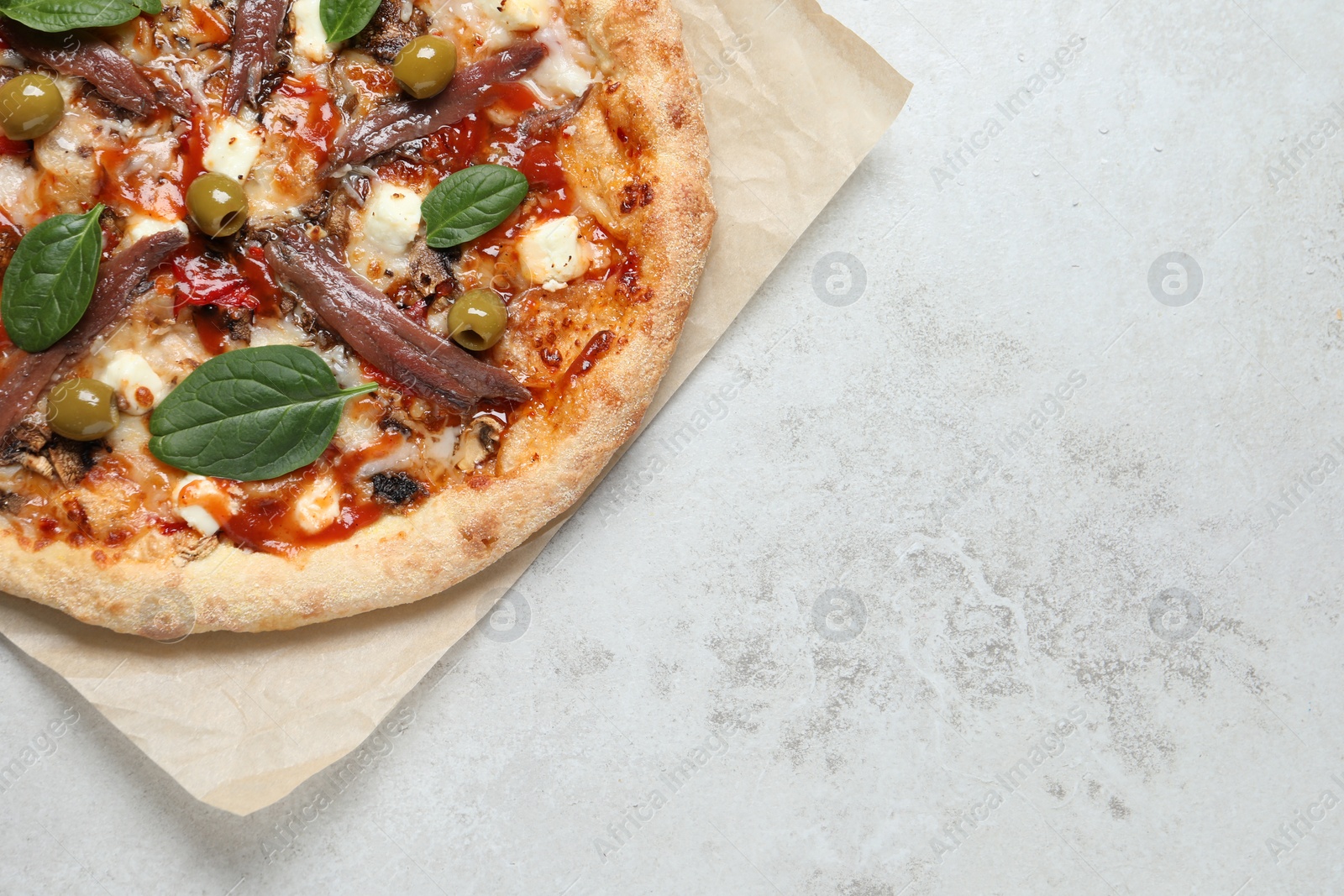 Photo of Tasty pizza with anchovies, basil and olives on white table, top view. Space for text