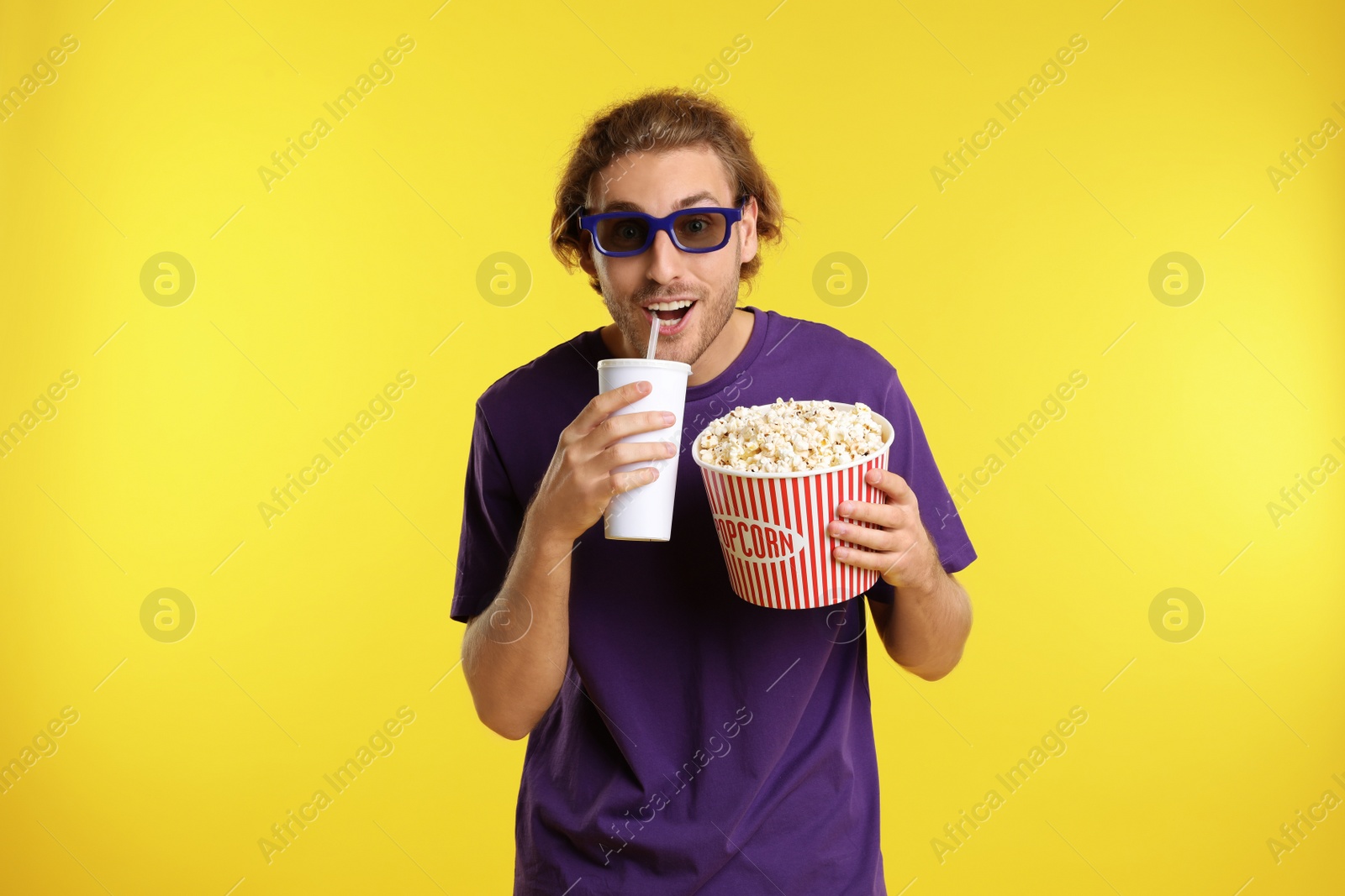 Photo of Emotional man with 3D glasses, popcorn and beverage during cinema show on color background