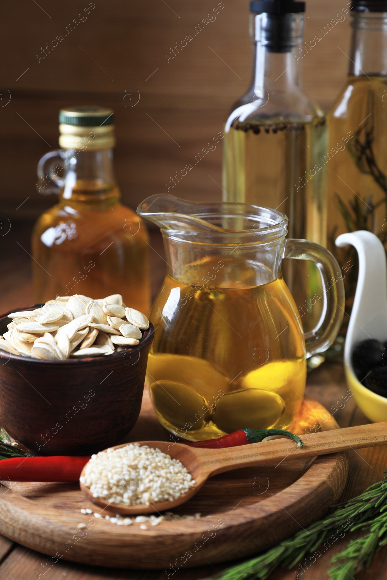 Photo of Different cooking oils and ingredients on wooden table