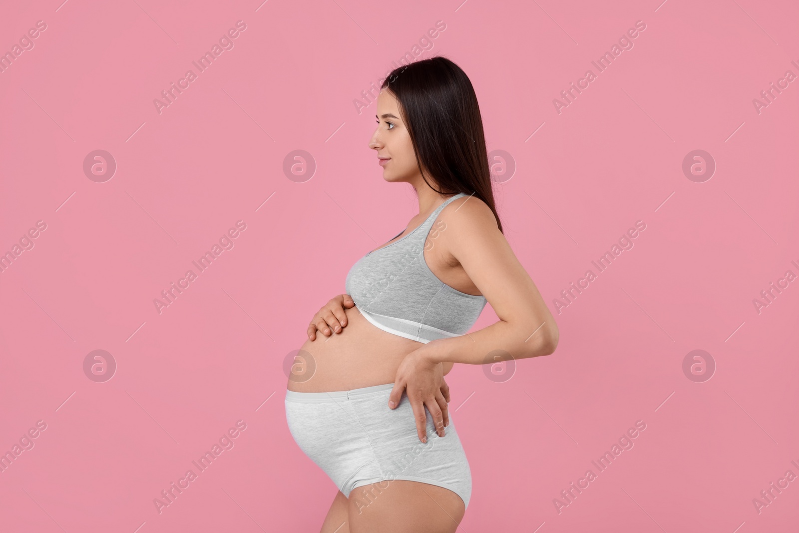 Photo of Beautiful pregnant woman in comfortable maternity underwear on pink background