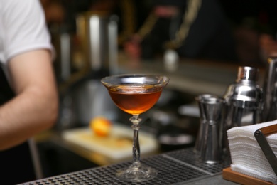 Photo of Glass of tasty cocktail on bar counter